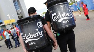 Hommes portant des sacs à l'effigie de la bière Carlsberg